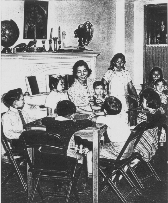 Dr. Mabel Lee sitting with children at the New York First Chinese Baptist Church.