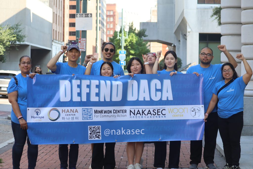 NAKASEC members stand with blue banner saying "Defend DACA"